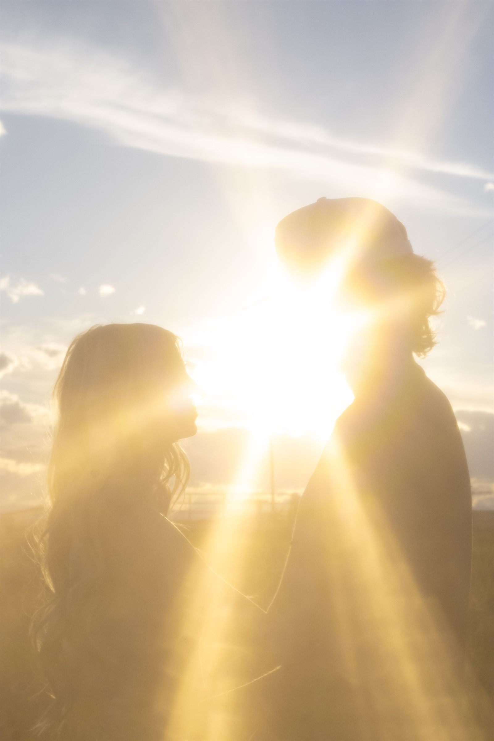 A couple silhouetted in golden hour sun rays.
